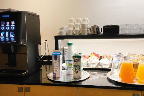 a kitchen counter with a coffee maker and glasses of orange juice at Onix Liceo in Barcelona