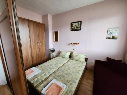 a small bedroom with a bed and a cabinet at Апартамент Панорамна гледка in Tryavna