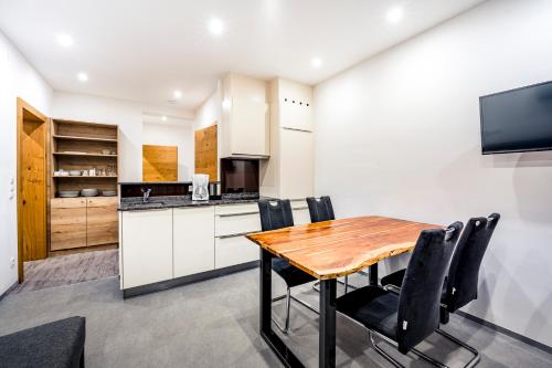 a kitchen and dining room with a wooden table and chairs at Quality Hosts Arlberg - AFOCH FEI - das Landhaus in Sankt Anton am Arlberg