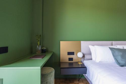 a bedroom with a bed and a desk with a lamp at Gaby Lake Suites in Como