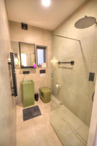 a bathroom with a shower with a green toilet at Beautiful one bedroom seafront apartment VPAL1-1 in Il-Furjana
