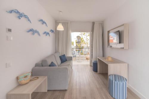 a living room with a couch and a table at Carema Club Resort in Fornells