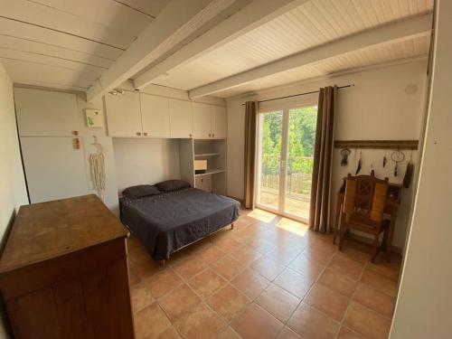 1 dormitorio con 1 cama y 1 mesa en una habitación en Jolie maisonnette avec piscine en Tourrettes-sur-Loup