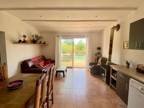 une cuisine et un salon avec une table et des chaises dans l'établissement Jolie maisonnette avec piscine, à Tourrettes-sur-Loup