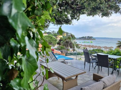 a wooden table and chairs on a patio overlooking the ocean at Apartment Lučka in Rab