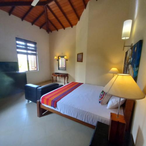 a bedroom with a bed and a lamp and a chair at Crown hills kandy in Kandy
