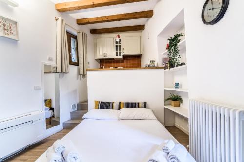 ミラノにあるSecret Navigli Suiteの小さなベッドルーム(ベッド1台、壁掛け時計付)