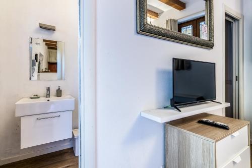 ミラノにあるSecret Navigli Suiteのバスルーム(洗面台付)、壁掛けテレビが備わります。