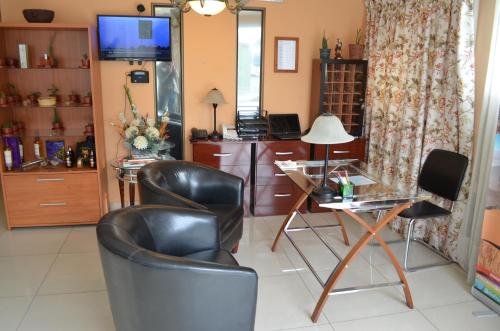 a living room with two chairs and a desk at Hotel Del Marques in Vallenar