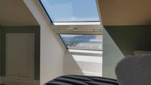a room with a skylight and a window at Coastal View House in Buncrana