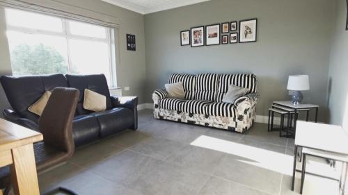 a living room with a couch and a chair at Coastal View House in Buncrana