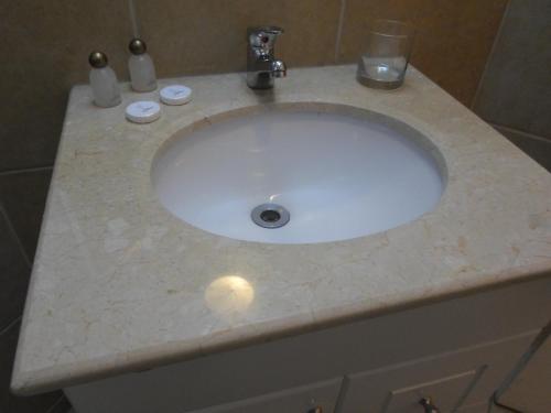 a bathroom sink with a marble counter top at Hotel Del Marques in Vallenar