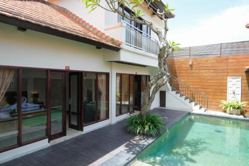 an external view of a house with a swimming pool at Bugan Villas in Seminyak