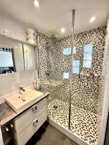 une salle de bain avec un lavabo et une douche dans l'établissement Beau T2 avec terrasse vue mer, à Cannes