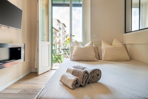 a large white bed in a room with a large window at Apartment Novolino With Balcony in Florence