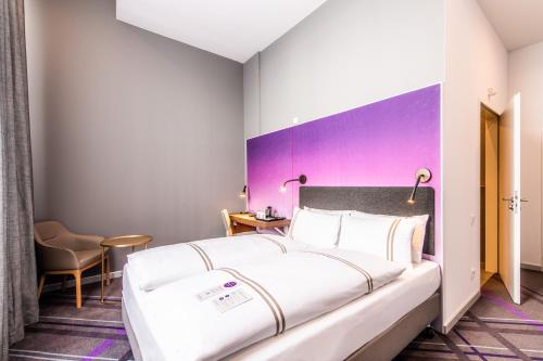 a bedroom with a large bed and a purple wall at Premier Inn Wuppertal City Centre in Wuppertal