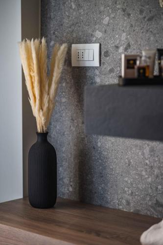 a black vase with feathers in it on a table at Gaby Lake Suites in Como