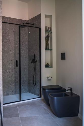 a bathroom with a shower with a blue tub and a sink at Gaby Lake Suites in Como