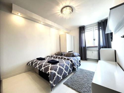 um quarto com uma cama e um lustre em INFLANCKA Apartment - Self Check-In 20h em Breslávia