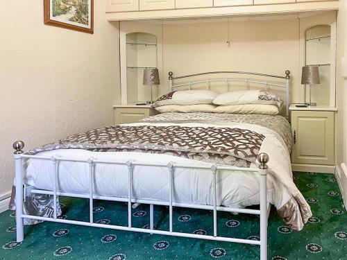 a white bed in a room with a green carpet at Pentargon View in Boscastle