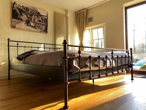 een slaapkamer met een bed in een kamer met een raam bij B&B de Muldermolen in Schinnen