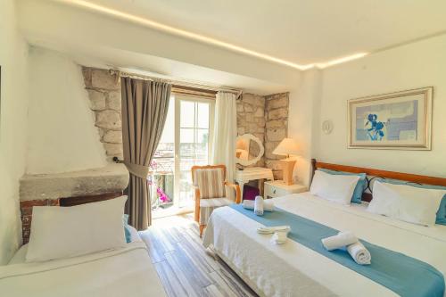 a hotel room with two beds and a window at Alacati Asmali Konak Hotel in Alacati