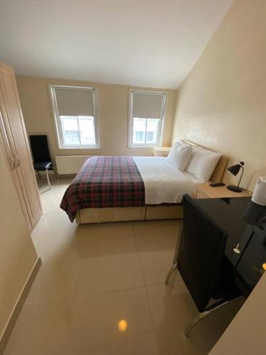 a bedroom with a bed and a flat screen tv at Studio to let in Covent Garden with kitchen in London