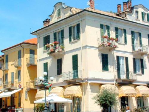 バヴェーノにあるCozy Mansion near Lake in Baveno Italyの白い大きな建物(窓に花箱付)