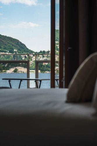 a bed with a view of a river and a bridge at Gaby Lake Suites in Como