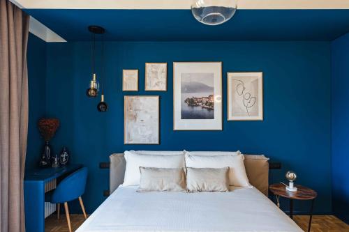 a blue bedroom with a bed and a blue wall at Gaby Lake Suites in Como
