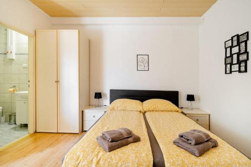 a bedroom with a bed with two towels on it at Airport Garden Room in Čilipi