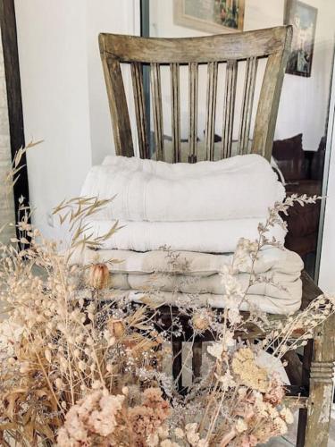 une pile de serviettes assises sur une chaise en bois dans l'établissement Le Charles - Campagne chic, à Jaux