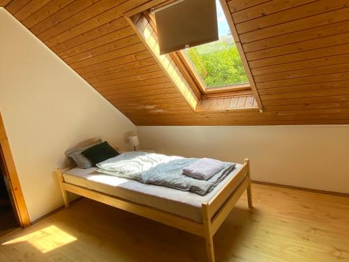 a bedroom with a bed with a skylight at Almáskert Vendégház in Mónosbél