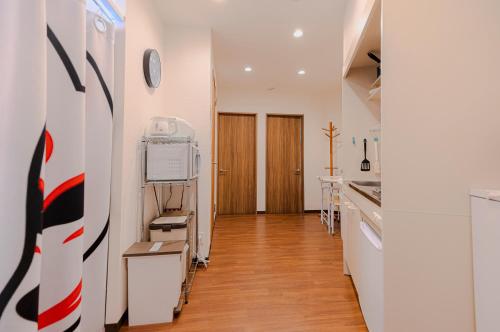 a kitchen with white walls and wooden floors at SKYE HOME in Tokyo