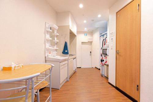 a kitchen with white cabinets and a table and a hallway at SKYE HOME in Tokyo