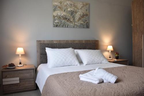 una camera da letto con un letto e due asciugamani di Salt and petals a Samotracia