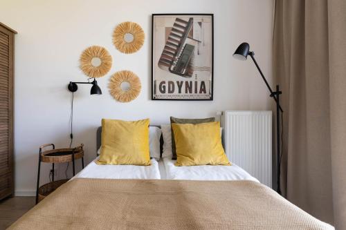 a bedroom with a bed with yellow pillows at Symphony Modern Tower Aparthotel in Gdynia