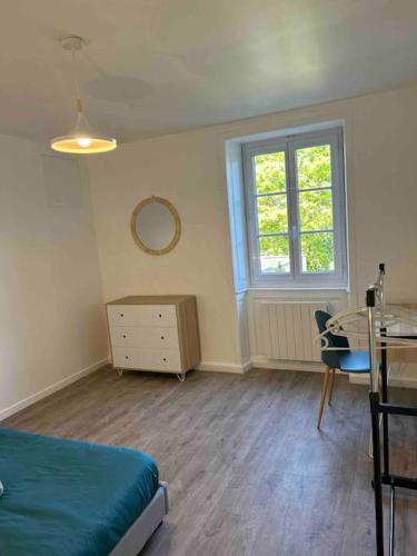 a bedroom with a bed and a desk and a window at Le St Martin Appart' in Coligny