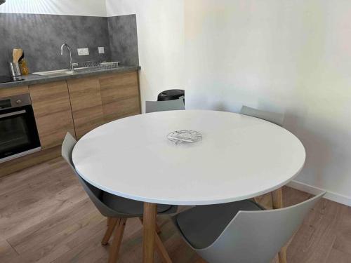 a white table and chairs in a kitchen at Le St Martin Appart' in Coligny
