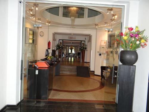 een lobby met een vaas met bloemen op een toonbank bij Tulip Inn Heerlen City Centre in Heerlen