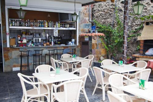 ein Restaurant mit weißen Tischen und Stühlen und eine Bar in der Unterkunft Apartamentos Miriam in Puerto Rico de Gran Canaria