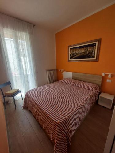 ein Schlafzimmer mit einem Bett mit einer orangefarbenen Wand in der Unterkunft Aganoor in Padua