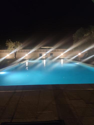 a blue swimming pool at night with lights at Masseria Parco di Castro in Montalbano