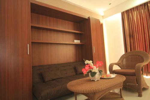 a living room with a couch and a table with flowers at Hotel on The Rock in Kupang