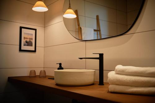 y baño con lavabo, espejo y toallas. en L'Aixart Aiguablava Hotel, en Begur