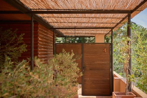 an open wooden door with a metal roof at L'Aixart Aiguablava Hotel in Begur