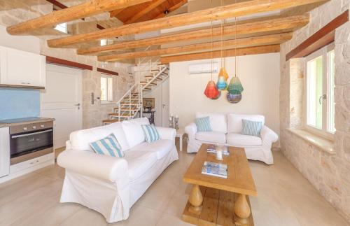 a living room with two white couches and a table at The Yiameli Collection - Meli in Skinária