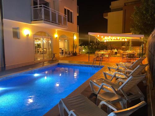 a swimming pool in front of a villa at night at Family Hotel Saga in Ravda