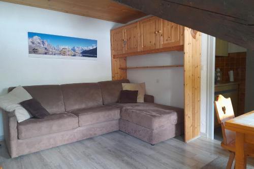 a living room with a couch and a table at Studio in the center of the village in La Clusaz