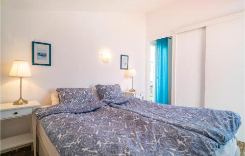 a bedroom with a bed with a blue comforter at Gorgeous Home In Estepona With Kitchen in Estepona